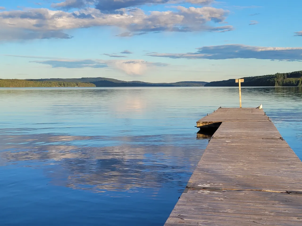 Lac calme à l'heure dorée — ponton de bois, eau miroir, parenthèse d'évasion